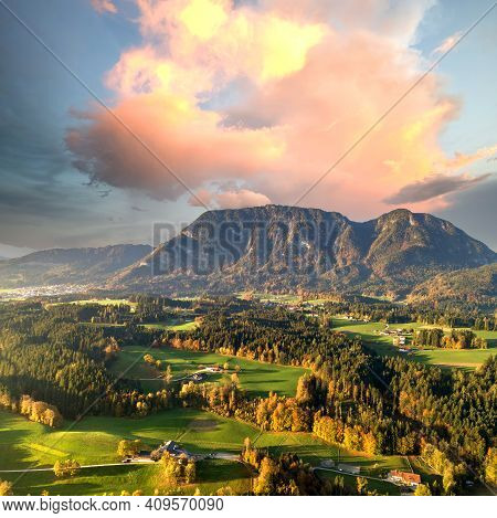 Aerial View Of Green Meadows With Villages And Forest In Austrian Alps Mountains.