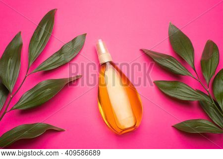 Suntan Oil On A Pink Background . Suntan Oil And Green Leaves. Vacation. Protect Your Skin From The 