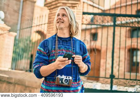 Young scandinavian tourist man smiling happy using smartphone at the city.
