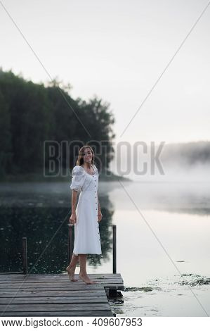 Tender Romanitc Sentimental Female Lady In The Morning On A Wooden Pier Near The Misty River In A Wh