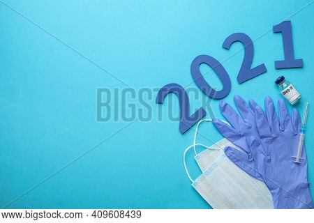 Flat Lay Composition With Coronavirus Vaccine And Number 2021 On Light Blue Background, Space For Te