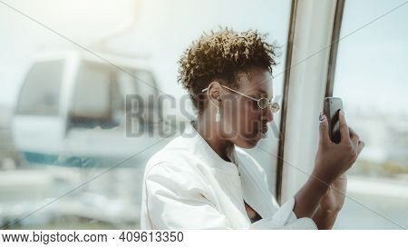 Portrait Of A Young Ravishing African Female In The Cableway Car Taking Pics Of Attractions Via Her 