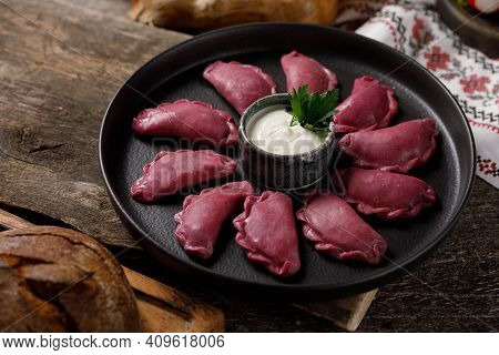 Delicious Traditional Russian Dumplings, Handmade Dough Painted With Beets. Still Life On A Wooden B