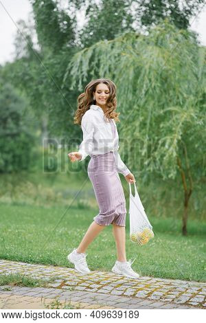 Healthy Food. Reusable Eco-friendly Fruit Shopping Bag. A Woman Holding A String Shopping Bag With F