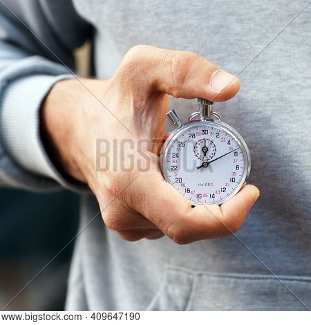 Trainer Holds Stopwatch In His Hand And Presses Start And Stop Button - Close Up