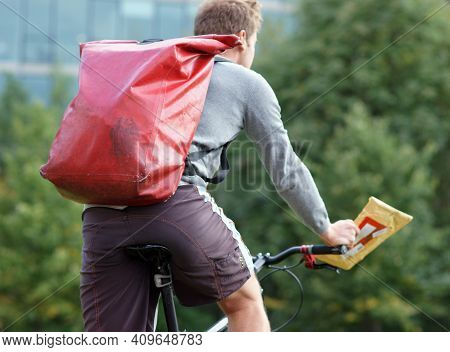 Bicycle Messenger In Berlin Delivering An Envelope