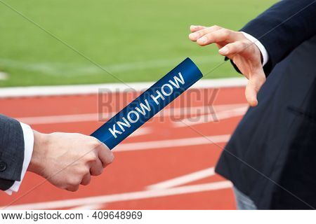 Businessmen Passing Baton In Relay Race In Stadium With The Word Know How