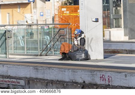 Terni,italy February 24 2021:clochard Black Woman With Black Bags Sitting At The Station