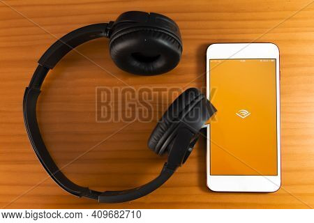 Spain, 02, 24, 2021. Mobile Phone With Audible Logo On Screen Close Up With Website On Laptop. Blurr