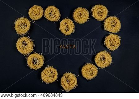 Paste Of Letters Of The Alphabet, On A Black Background With A Heart Shape With Capelli Pasta. In Th