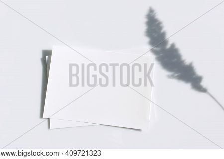 Mockup Poster Or Flyer For Presentation White Sheets Of Paper With Shadow Of Ear On A Gray Backgroun