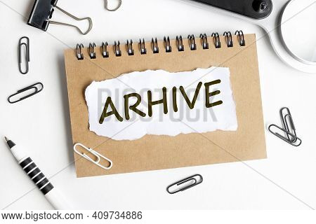 Arhive. Text On White Paper Over White Background. Notebook, Pen.