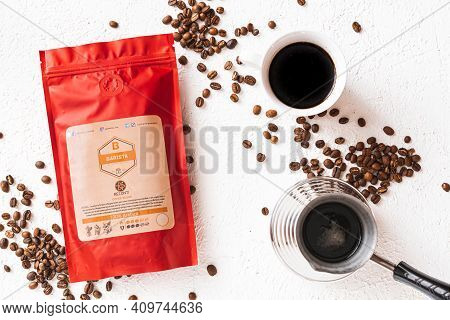 Tiraspol, Moldova - February 12, 2021: Red Coffee Bag With Degassing Valve, Cup Of Coffee, Coffee Be