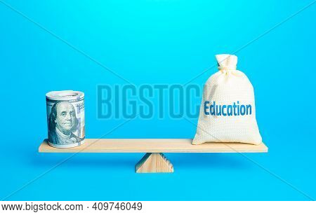 Bundle Of Dollars And A Bag Of Education On Scales. Investments Of Budgetary Funds In The Educationa