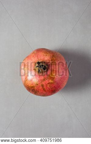 Red Garnet In The Center Of Vertical Photo On A Gray Background. Minimalism. Top View