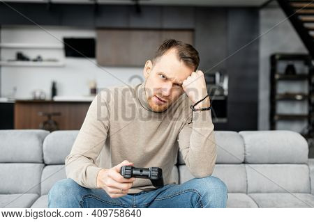 Upset Young Adult Man Sitting With Joystick In Hand, Playing Video Games, Game Over, Annoyed, On Sel