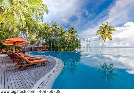 Summer Vacation At A Luxury Resort With Infinity Pool With Amazing Green Palm Trees Under Blue Sky. 