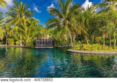 Summer Vacation At A Luxury Resort With Infinity Pool With Amazing Green Palm Trees Under Blue Sky. 