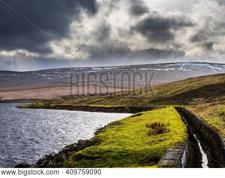 Angram reservoir with drainage channel and mountains. Nidderdale. Yorkshire Dales