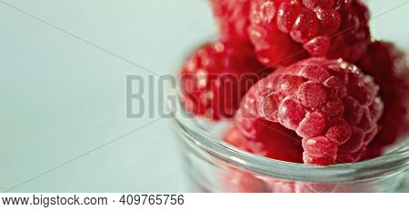 Frozen Raspberries Close-up In Glass Cup On Blue Background Close-up, Copy Space, Selective Focus, H