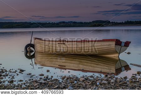 Boat On The Lake Near Mullingar Town In Ireland With Reflection In The Water At Sunset