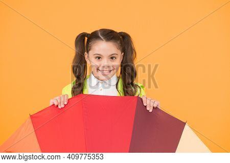 Hiding From Rain. Smiling Schoolgirl Peeking Out Of Colorful Umbrella. Autumn Rain. Going To School 