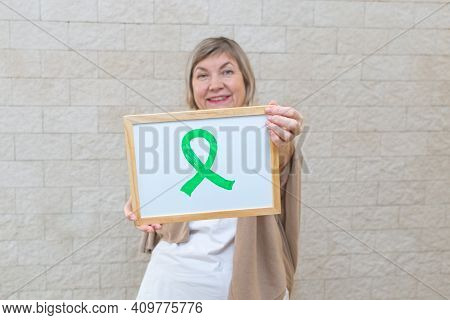 Woman Holds A Sign With A Green Ribbon For Awareness And Support Of People Living With Disease. Ment