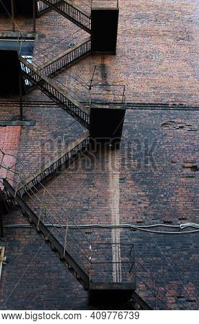 Metal fire escape on facade of old building, summer