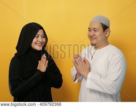 Happy Asian Muslim Couple Doing Greeting Gesture, Apologize And Forgiving Each Other On Eid Mubarak 