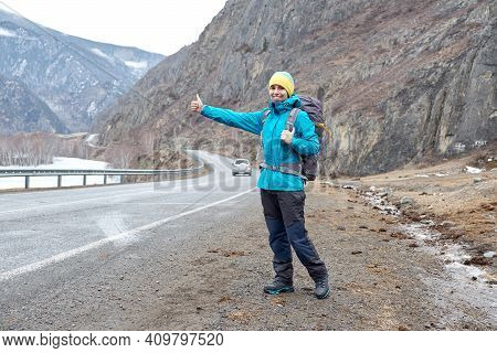Travel Woman Hitchhiking. Beautiful Young Female Hitchhiker By The Road During Vacation Trip In Moun