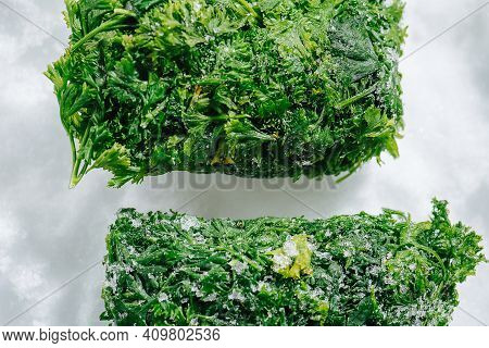 Cropped Frozen Parsley Green Briquettes On A Grinded Ice. Top View.