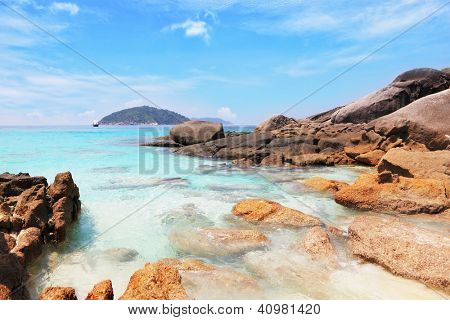 Similansky islands, Andaman Sea, Thailand.The thinnest white sand of a beach adjoins with huge brown rocks and azure water.