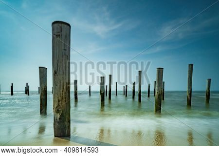 Long Exposure Seascape. Taken At The North Sea In Petten With The Pole Village In The Sea, Blue Sky,