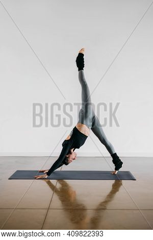 Fit Young Woman Coach Practices Individual Hatha Yoga On A Mat In A White Background. Female Instruc