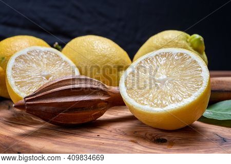 Fresh Ripe Yellow Italian Lemons And Wooden Juice Squeezer, New Harvest