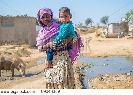 Rajasthan. India. 07-02-2018. Portrail Of A Female Adolescent Carrying Her Litthe Brother On Her Arm