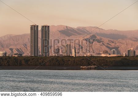 Ras Al Khaimah, United Arab Emirates Corniche Evening View To Hajar Mountains And Towers At Sunset.