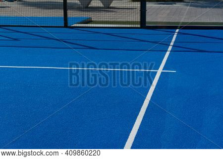 Bright Blue Tennis, Paddle Ball Or Pickleball Court Close Up Of Base Service Line Outdoors.