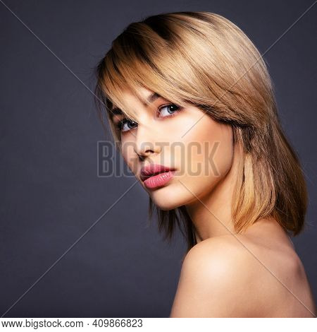 Blone woman with a short hair, fringe.  Sexy blonde woman.  Attractive blond model with blue eyes. Fashion model with a smokey makeup. Closeup portrait of a pretty woman. Creative short hairstyle.