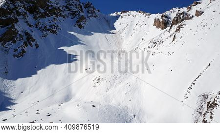 There Was An Avalanche In The Mountains. Top View From The Drone. Steep Slopes And Large Rocks. A Da