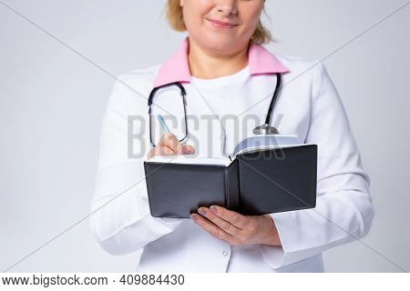 Cropped, Close Up Photo Of Female Nurse Handwrite Patient Anamnesis In Medical Journal At Workplace,