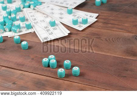 Many Barrels With Numbers And Cards For Lotto Or Russian Bingo Table Game On Wooden Surface. Russian