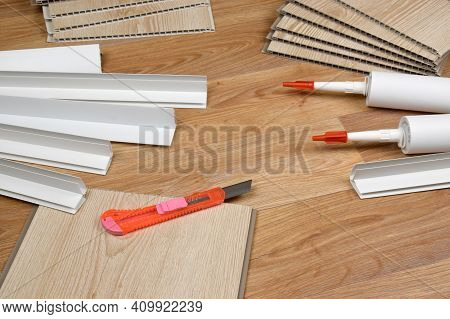 Set Of Items For Pvc Ceiling Indoor Works. Assembly Adhesive Bottles And Pvc Panels With Plastic Cor
