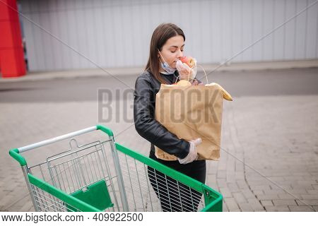 Groceries In Females Hand By The Car Truck. Woman In Protective Mask And Disposable Gloves. Fresh Fr