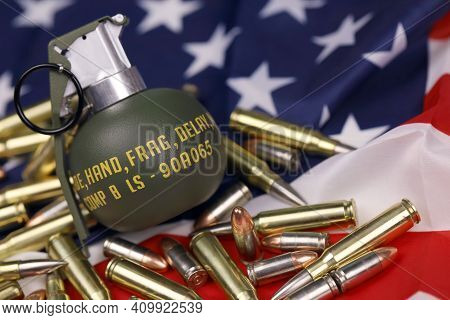 M67 Frag Grenade And Many Yellow Bullets And Cartridges On United States Flag. Concept Of Gun Traffi