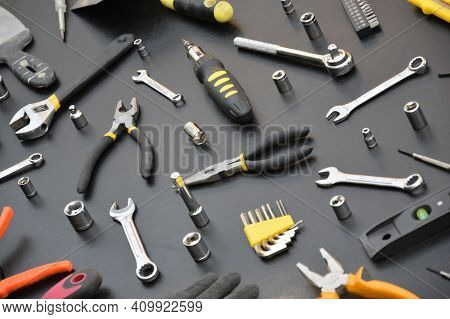 Handyman Tool Kit On Black Wooden Table. Many Wrenches And Screwdrivers, Pilers And Other Tools For 