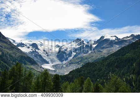 Morteratsch Glacier In The Canton Of Grisons Engadin With Green Forest In The Foreground. Swiss Alps