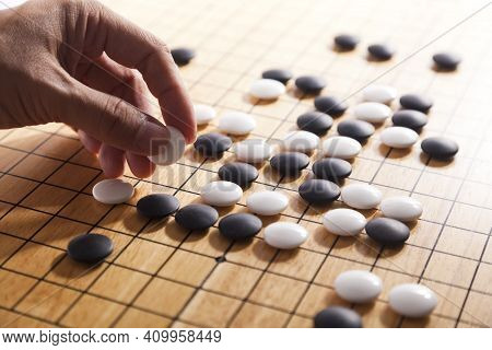 Player\'s Hand Put Stone On The Game Board - An Ancient Game Also Known As Baduk In Korean, Weiqi In