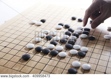 Player\'s Hand Put Stone On The Game Board - An Ancient Game Also Known As Baduk In Korean, Weiqi In