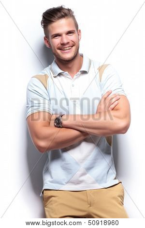 young casual man laughing while holding his arms crossed. on white background